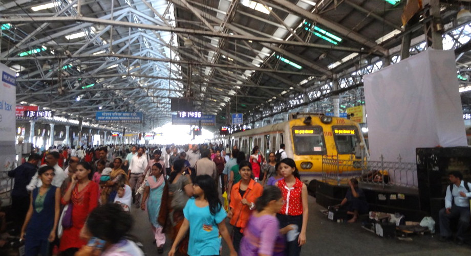 Im Bahnhof vom Mumbai mit Zug und indischen Fahrgästen